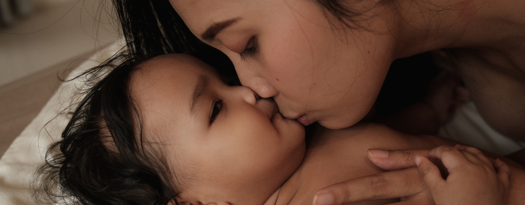 mother kissing baby