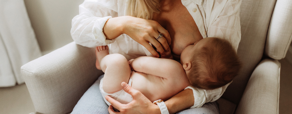 woman breastfeeding son on arm chair