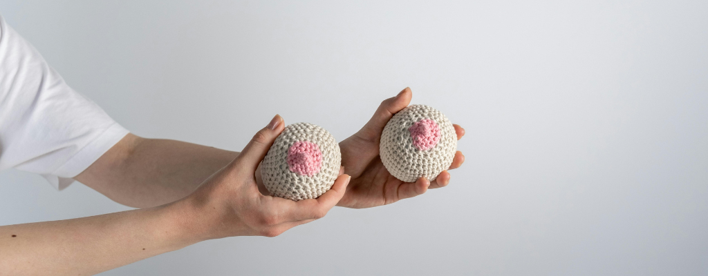 woman holding knitted breasts