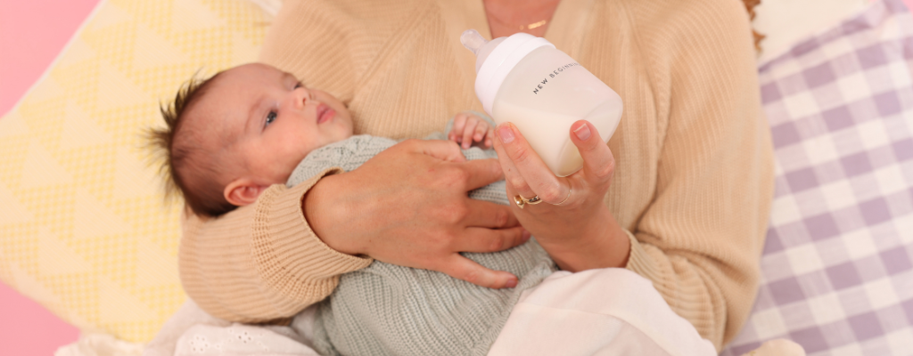 mum feeding baby with silicone outer glass bottle