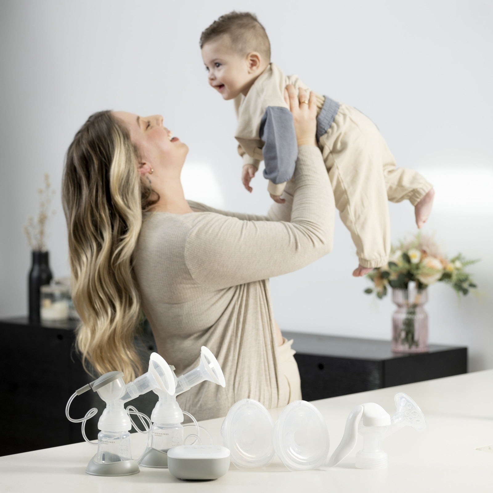 woman holding child with breast pump