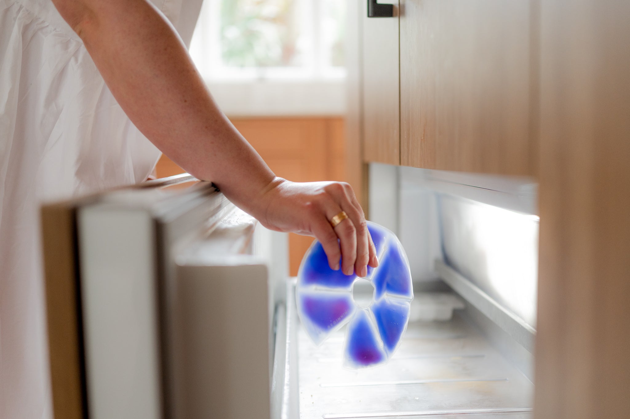 woman storing hot and cold breast pad into the freezer